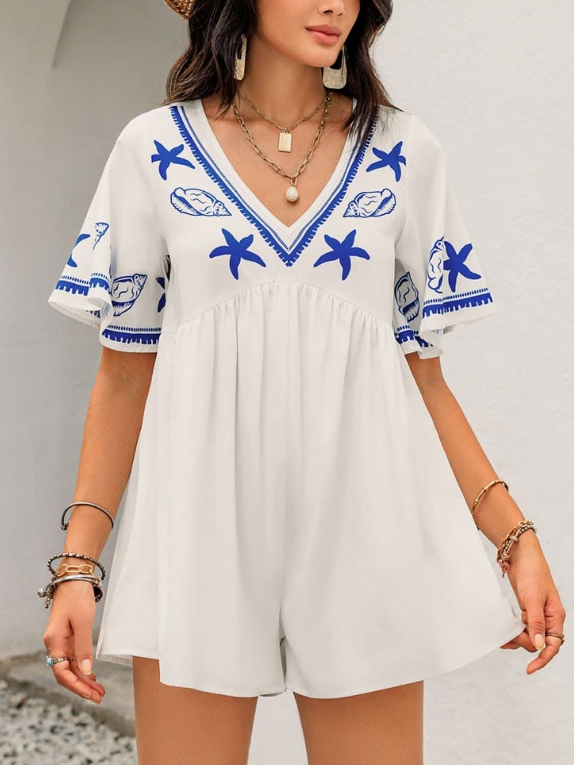 Chic v-neck romper with sheer details and blue starfish design, stylish and comfortable fit.