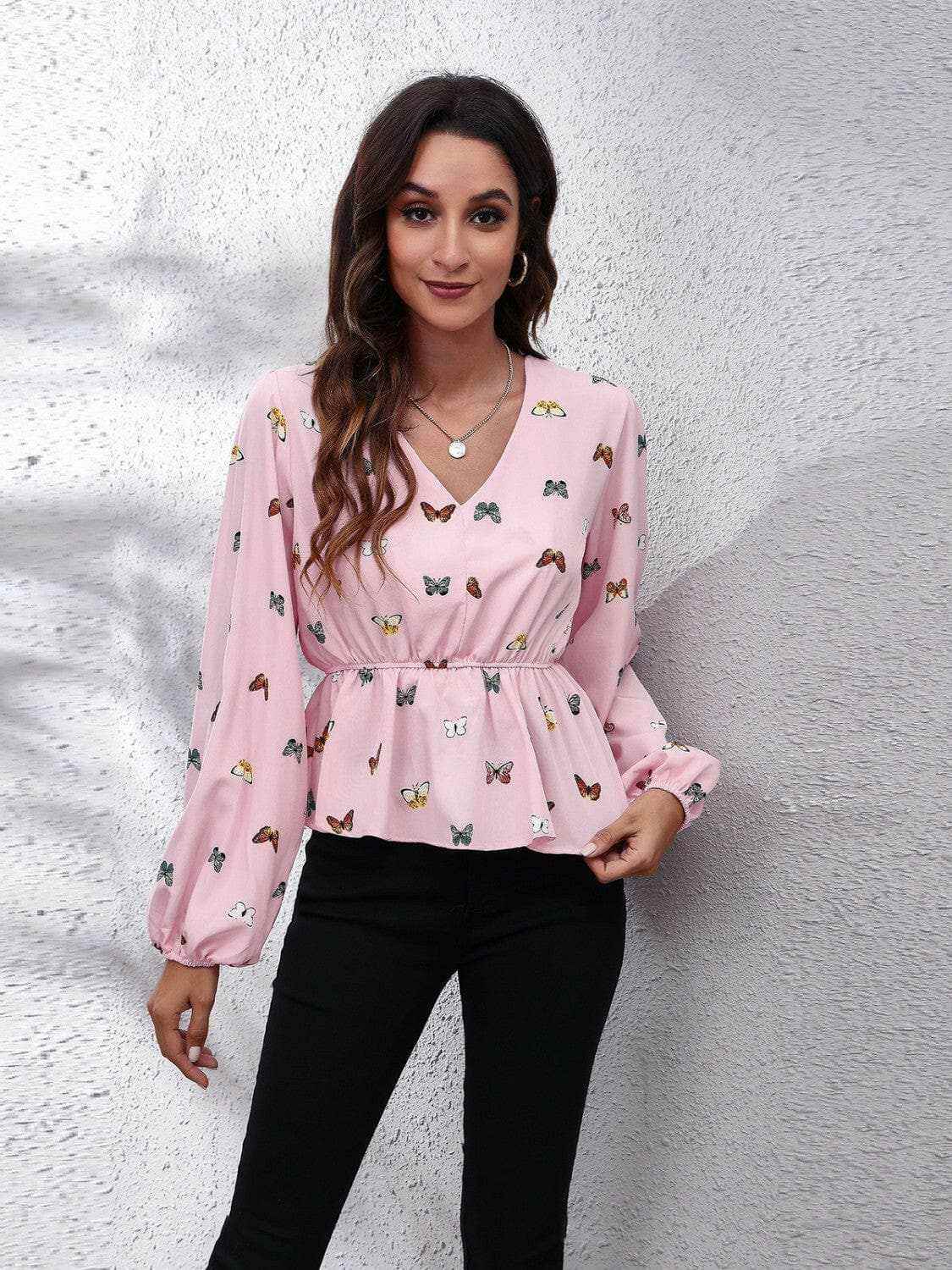 Chic butterfly peplum blouse with V-neck and balloon sleeves in soft pink.