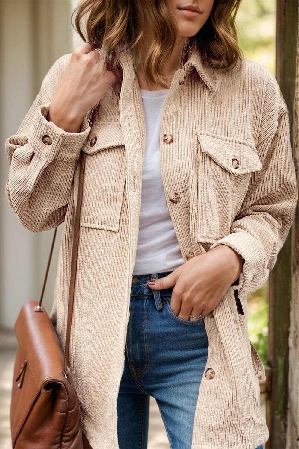 Cozy button-up shacket with pockets in beige, worn over a white top and jeans.