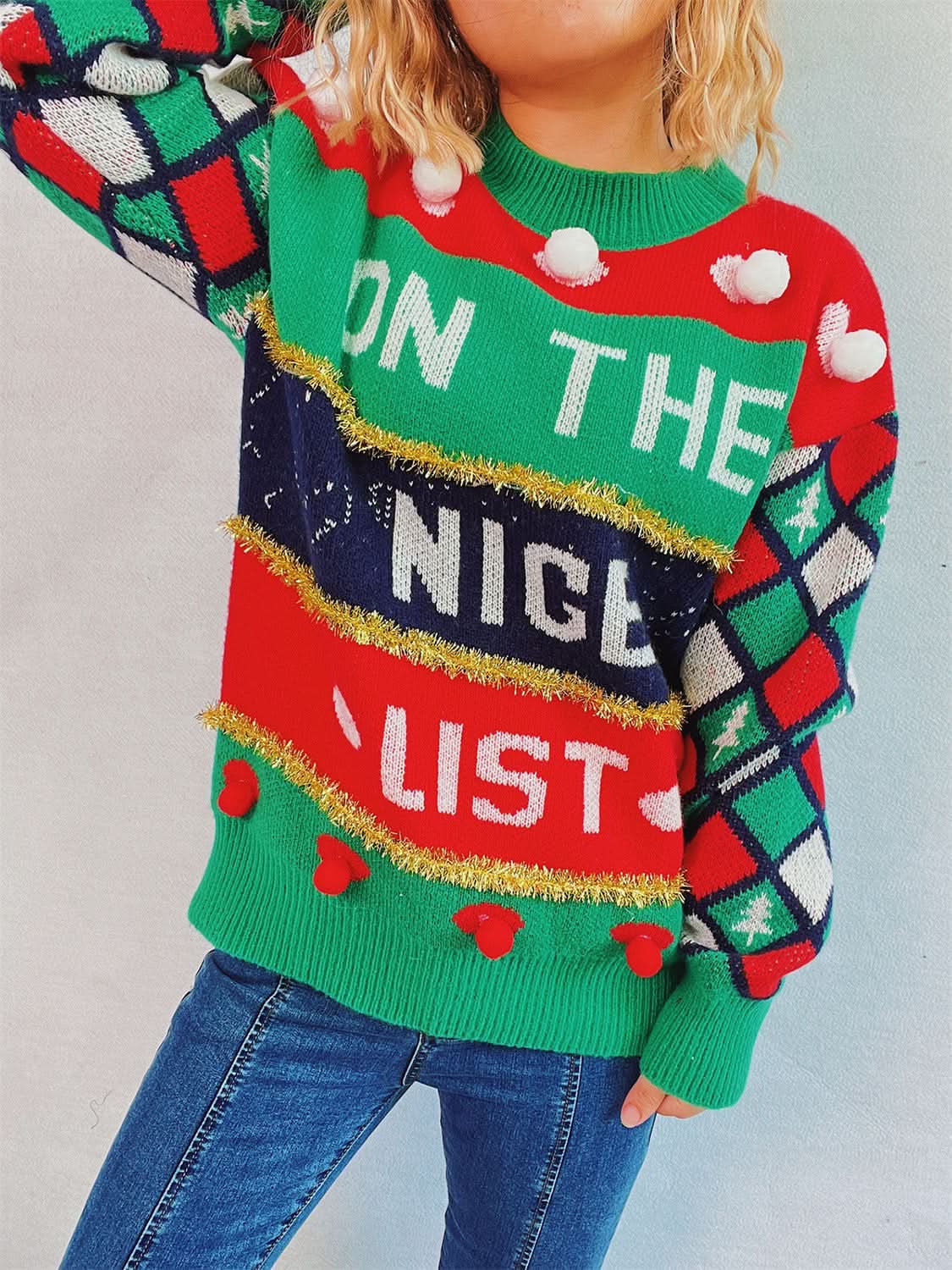 Chic pom-pom knit pullover top with festive design and colorful patterns.