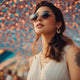 Woman wearing sunglasses under a canopy of colorful lights.