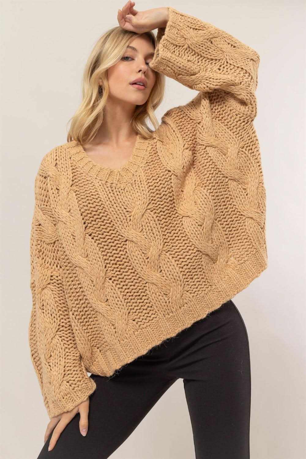 Blonde model wearing HYFVE cable knit V-neck sweater in camel color.