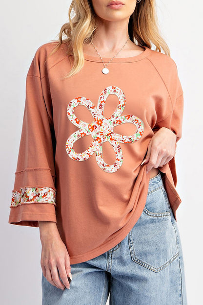 Floral graphic wide-sleeve top with exposed seam detail in grapefruit orange