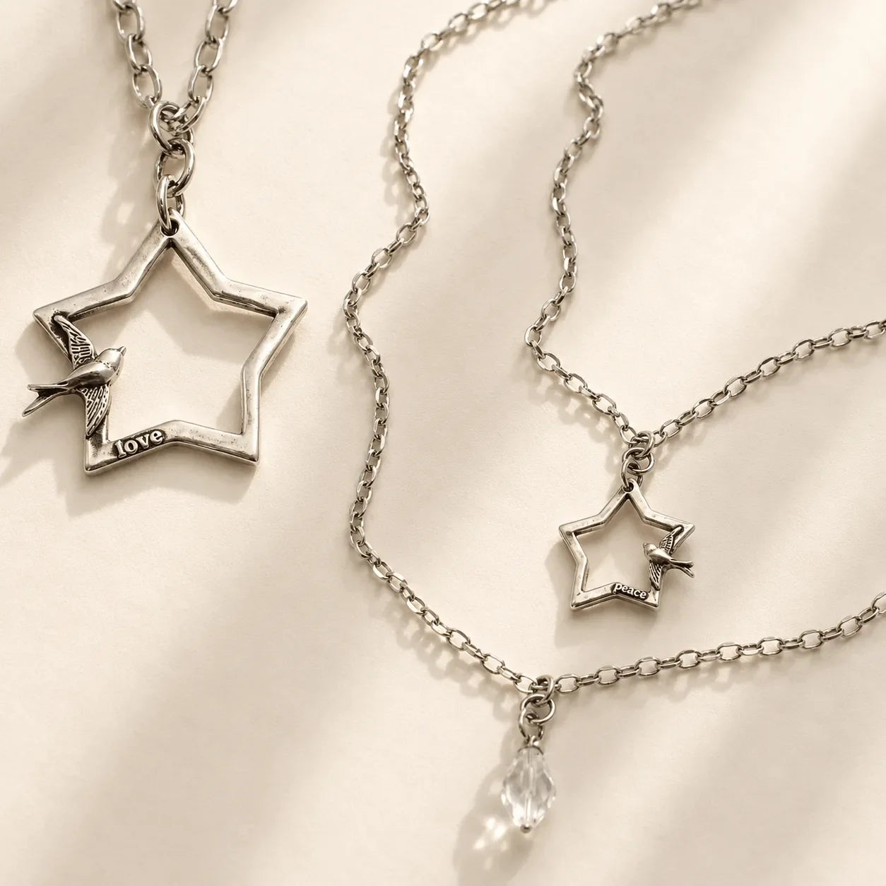 Side view of the Katia Designs Peace & Love Star and Bird Original Lite Necklace, showing the quality of the long chain and p