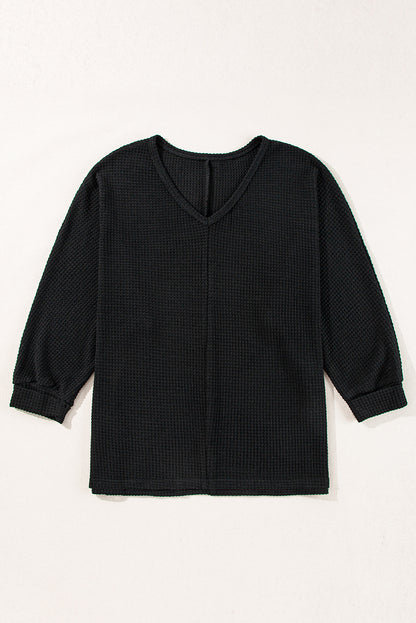 Chic black waffle knit V-neck top with side slits and loose fit