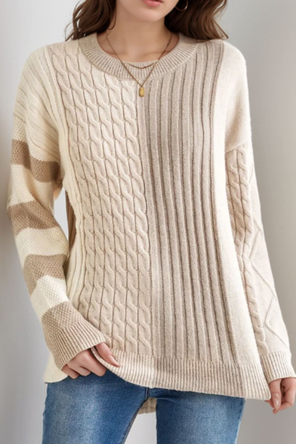 Cable-knit color block round neck sweater with casual fit design.