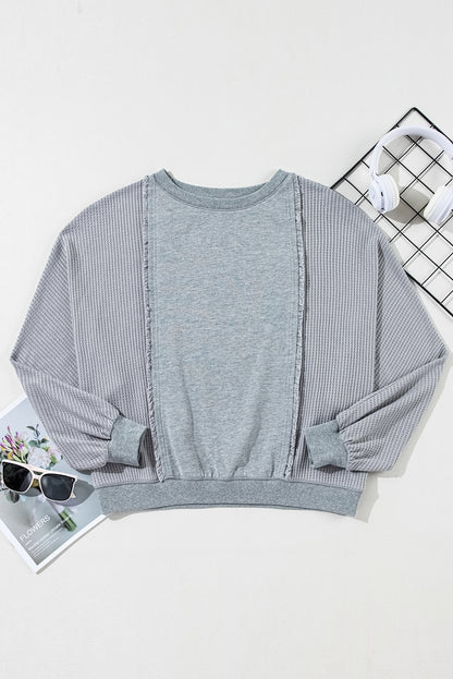 Chic light grey waffle patchwork pullover with raw hem details