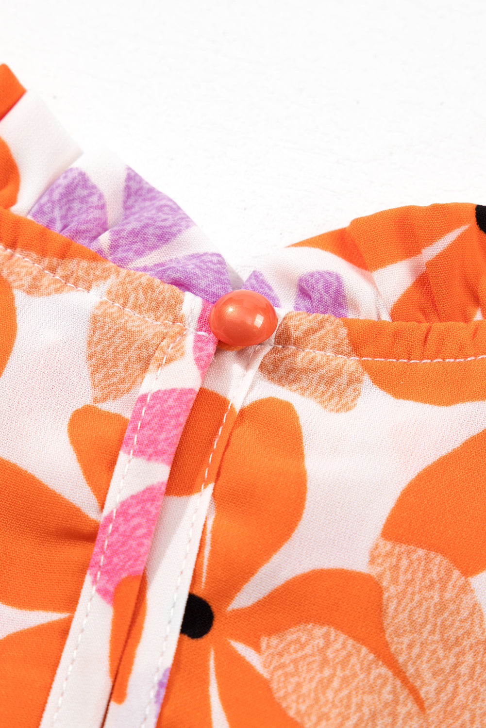 Floral delight: Orange ruffled sleeve top with smocked detail