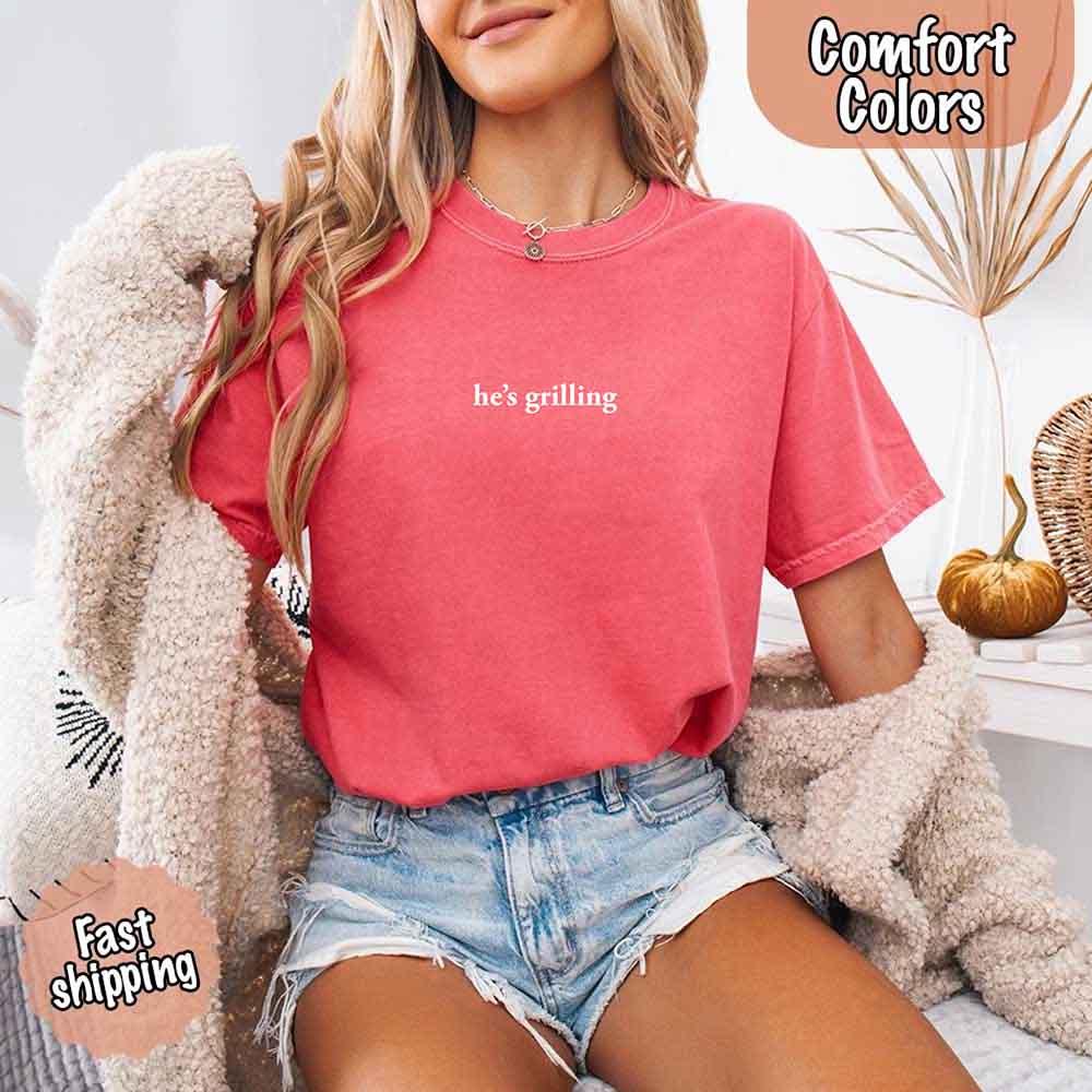 Model wearing the Adorb.co He’s Grilling BBQ shirt paired with denim shorts for a casual, stylish summer outfit.