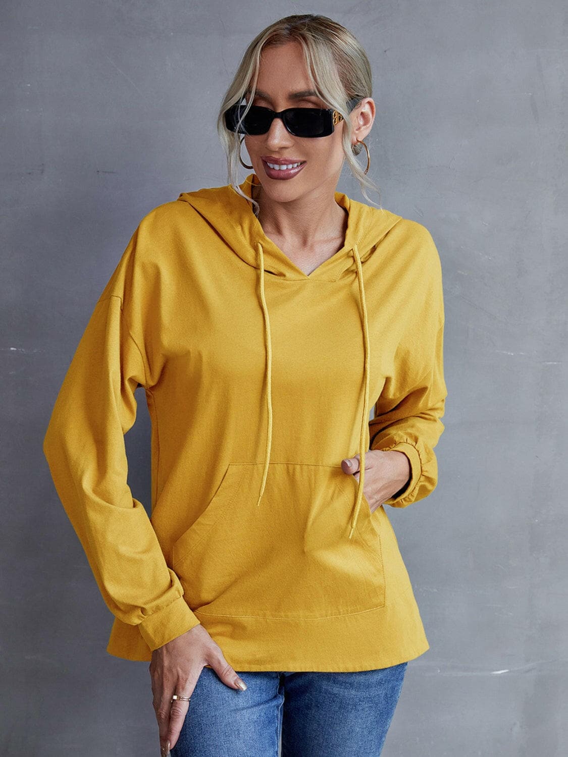 Drawstring pocketed dropped shoulder hoodie in mustard yellow, featuring trendy design and functional pockets.