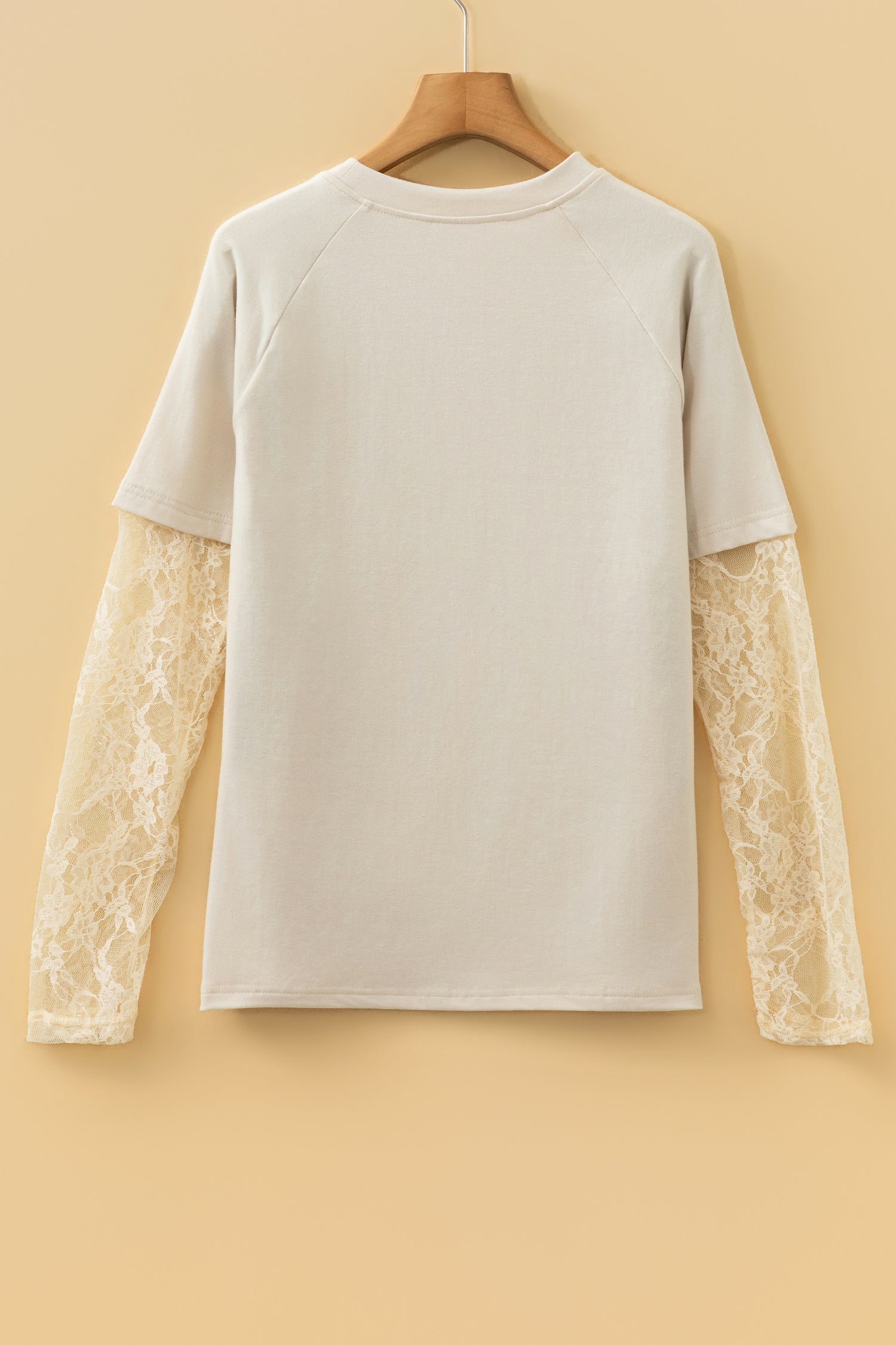Detail shot of the sleeve and cuff of the Dear-Lover Jet Stream Solid Color Long Sleeve T Shirt with intricate lace patchwork.
