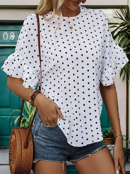 Slit polka dot round neck half sleeve blouse with ruffled accents and buttoned closure.