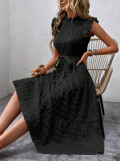 Ruffled cap sleeve midi dress in black with waist tie and textured fabric.