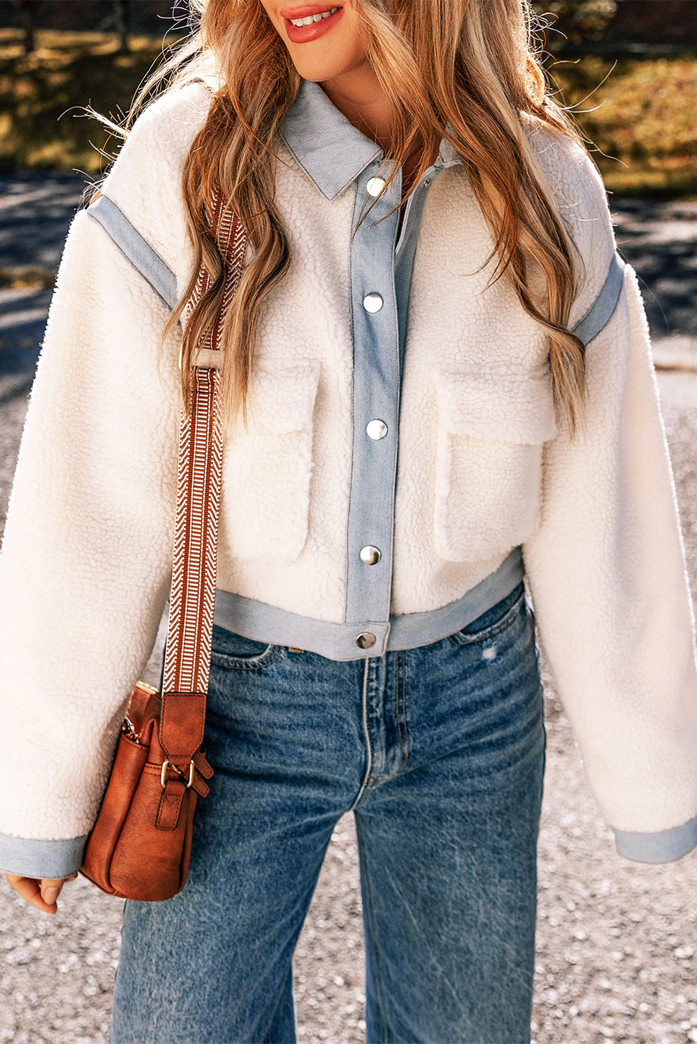 Chic white sherpa jacket with contrast trim and snap button closure.