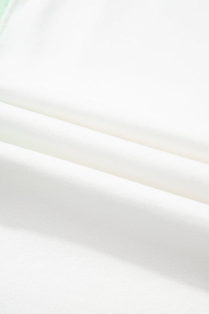 Light green color block t-shirt fabric close-up showing soft texture and exposed seams.
