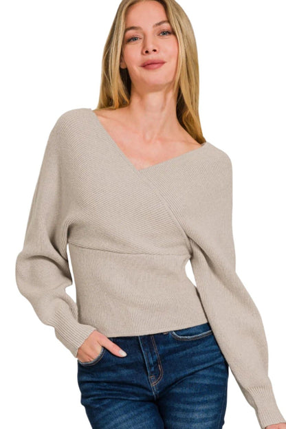 Woman wearing Zenana ribbed cross wrap sweater, featuring unique design and soft viscose material.