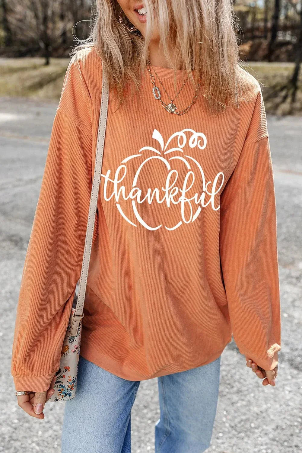 Graphic round neck long sleeve sweatshirt in orange with "thankful" print.