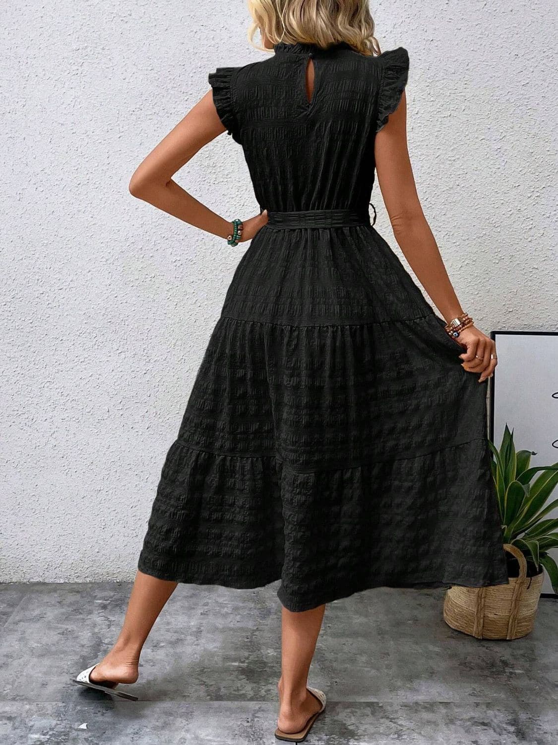 Ruffled cap sleeve midi dress in black, featuring a tied waist and tiered skirt, made of 95% polyester and 5% elastane.