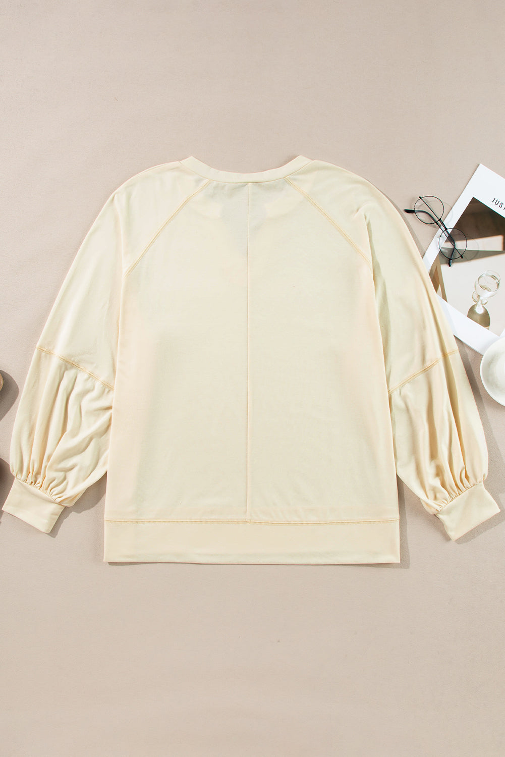 Chic apricot long sleeve top with notched neckline and exposed stitching