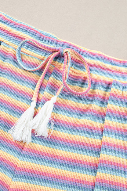 Chic pink striped rainbow tee and tasseled wide leg pants ensemble