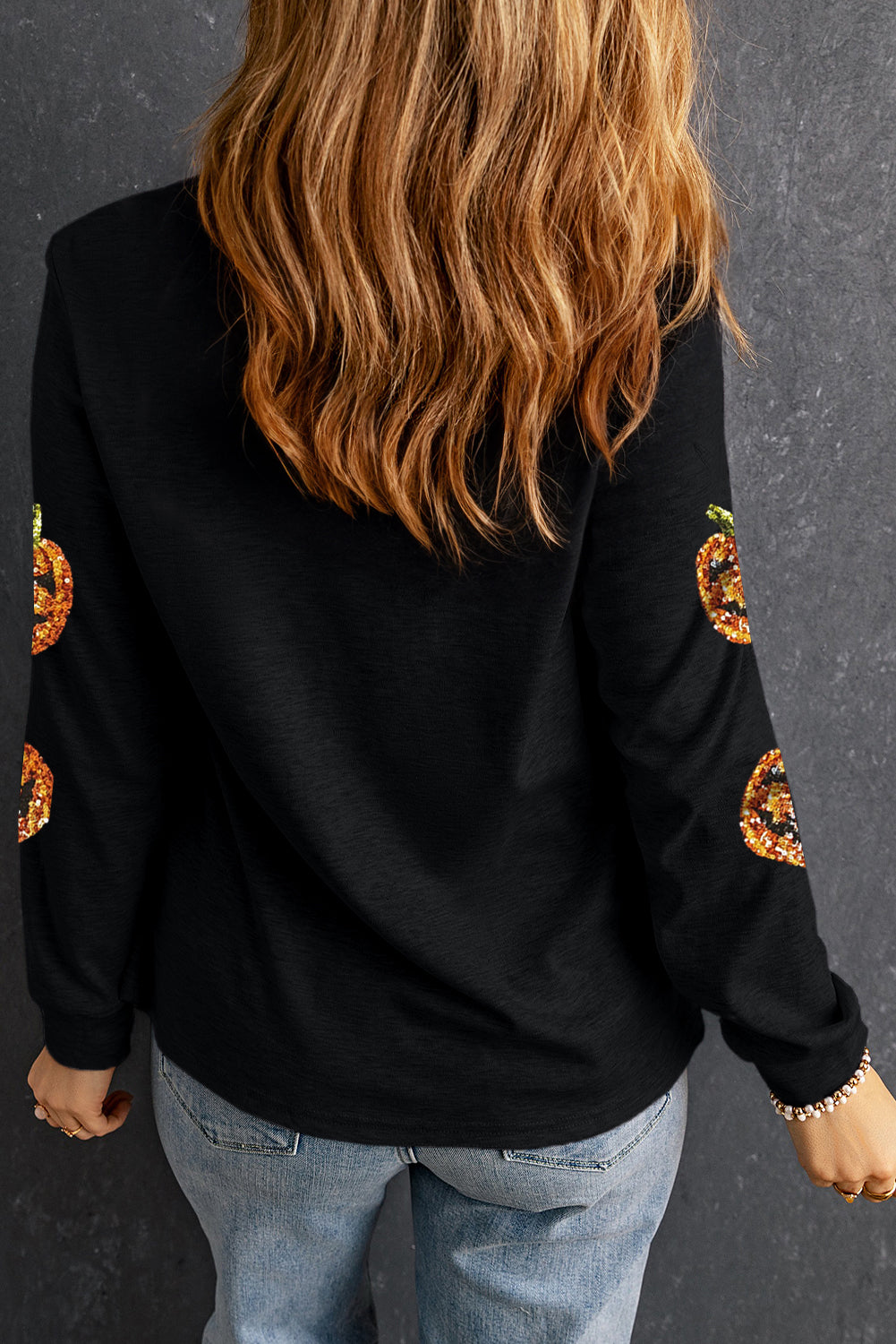 Sparkling pumpkin face pullover for a spooky Halloween look