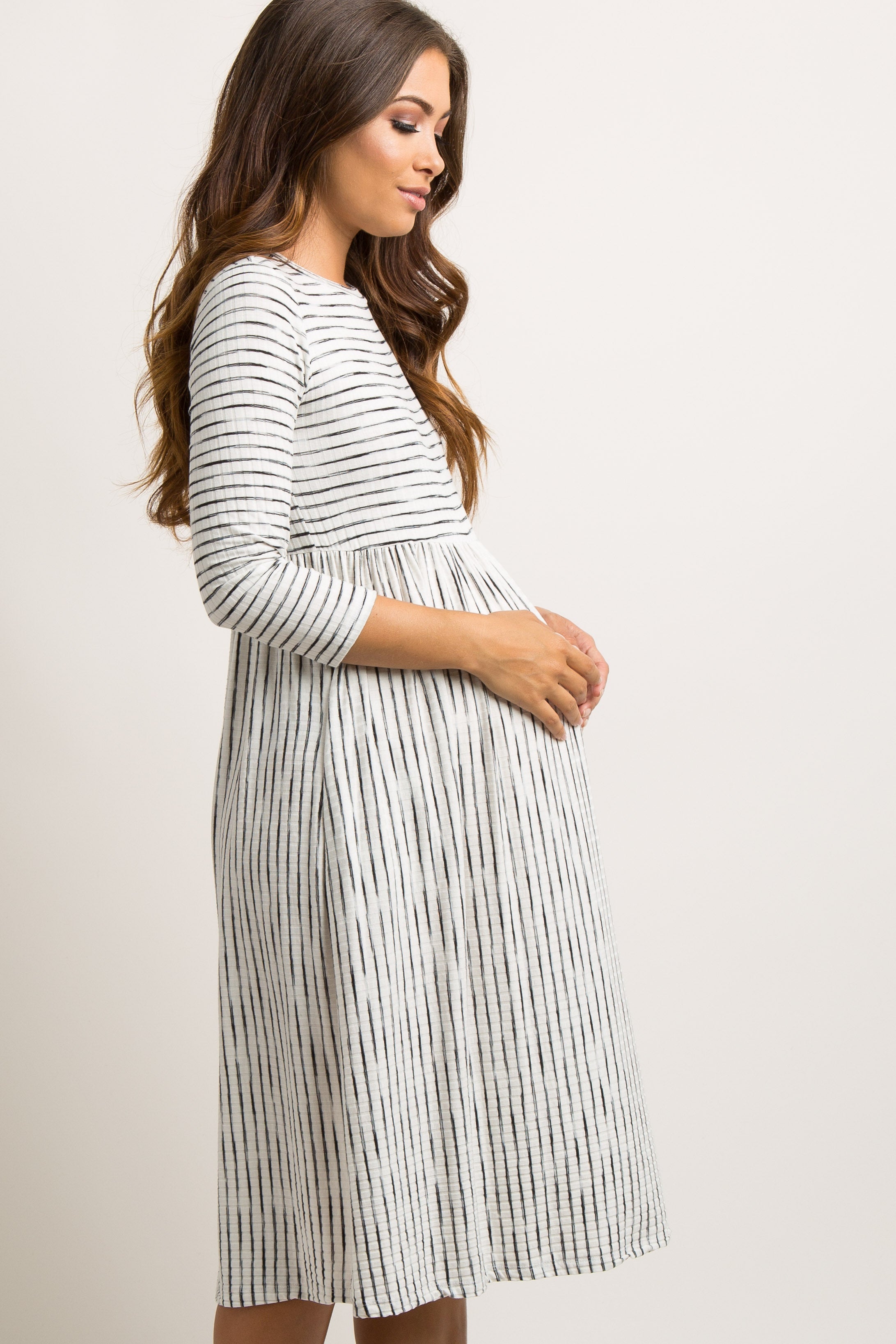 Close-up of the PinkBlush Ivory Ribbed Striped Maternity Midi Dress texture, revealing the soft ribbed knit and subtle stripe