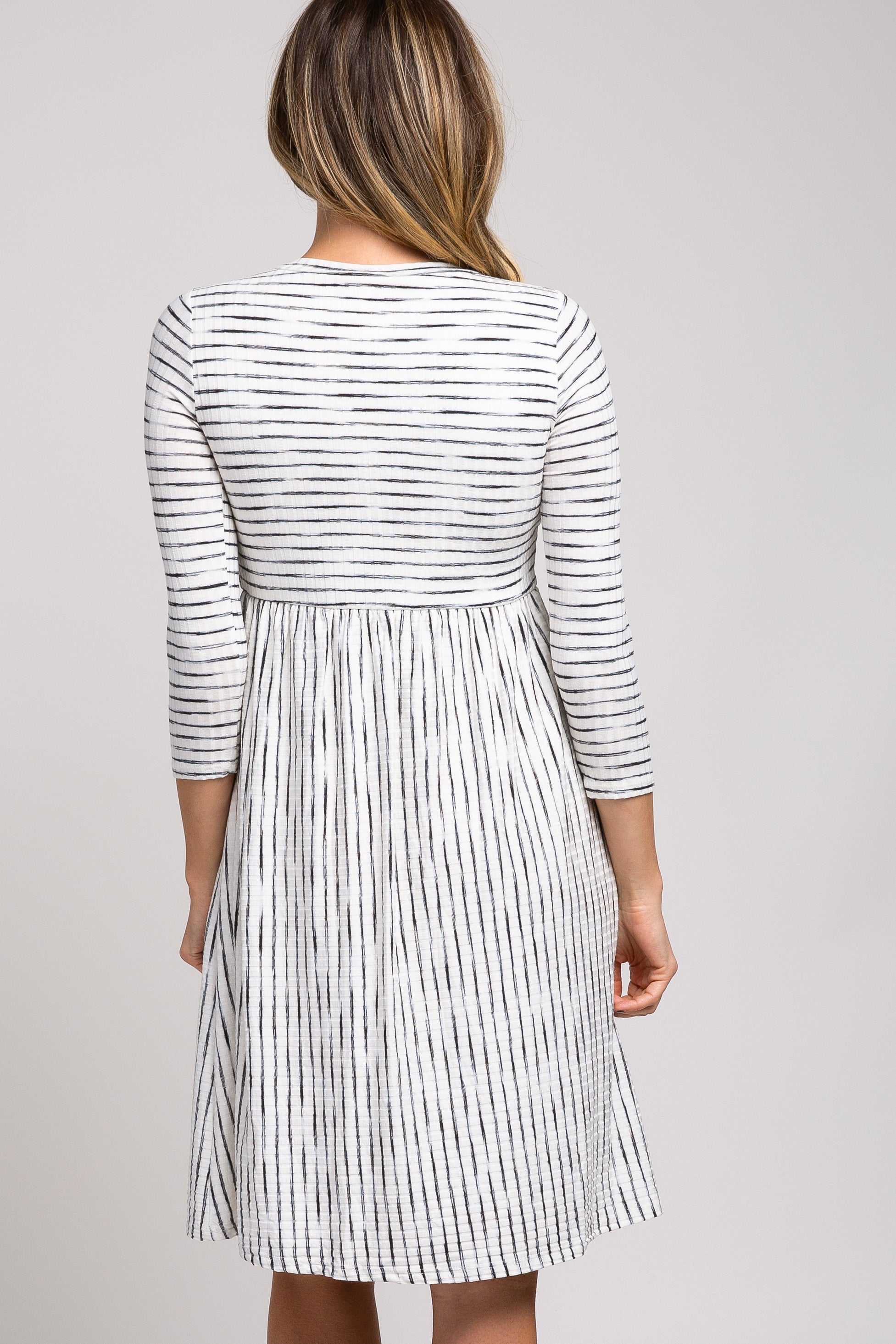 PinkBlush Ivory Ribbed Striped Pleated Midi Dress, a close-up view of the subtle striped pattern and luxurious fabric texture
