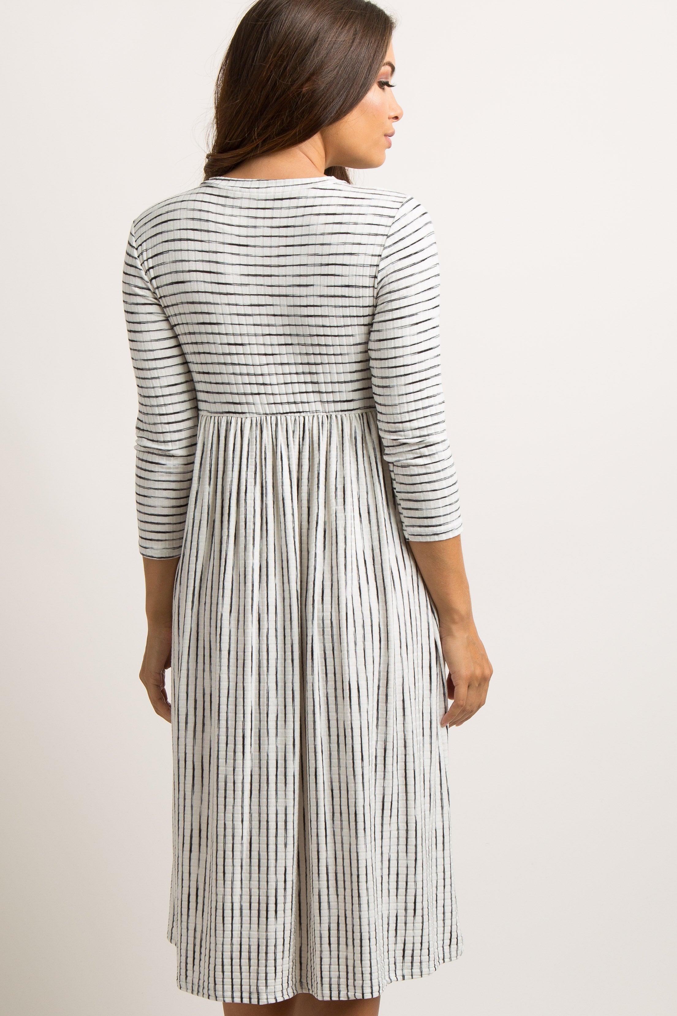 PinkBlush Ivory Ribbed Striped Maternity Midi Dress worn by a model, demonstrating its comfortable stretch and everyday wear