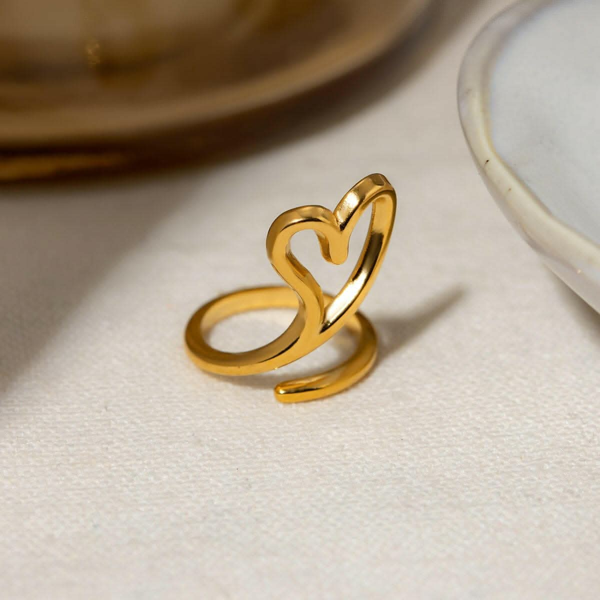 Gold-plated stainless steel heart bypass ring with cutout design, adjustable size.