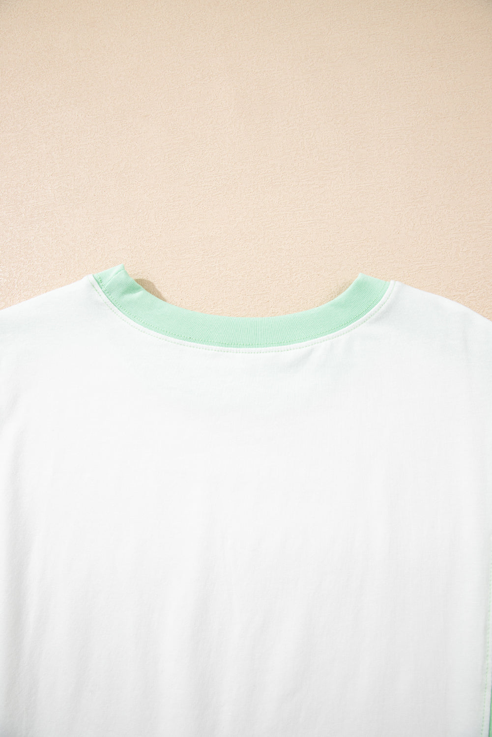 Light green color block crew neck t-shirt with exposed seams and chic design.