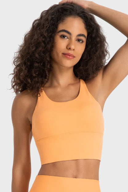 Sporty crisscross fitness bra with round neck in orange color.