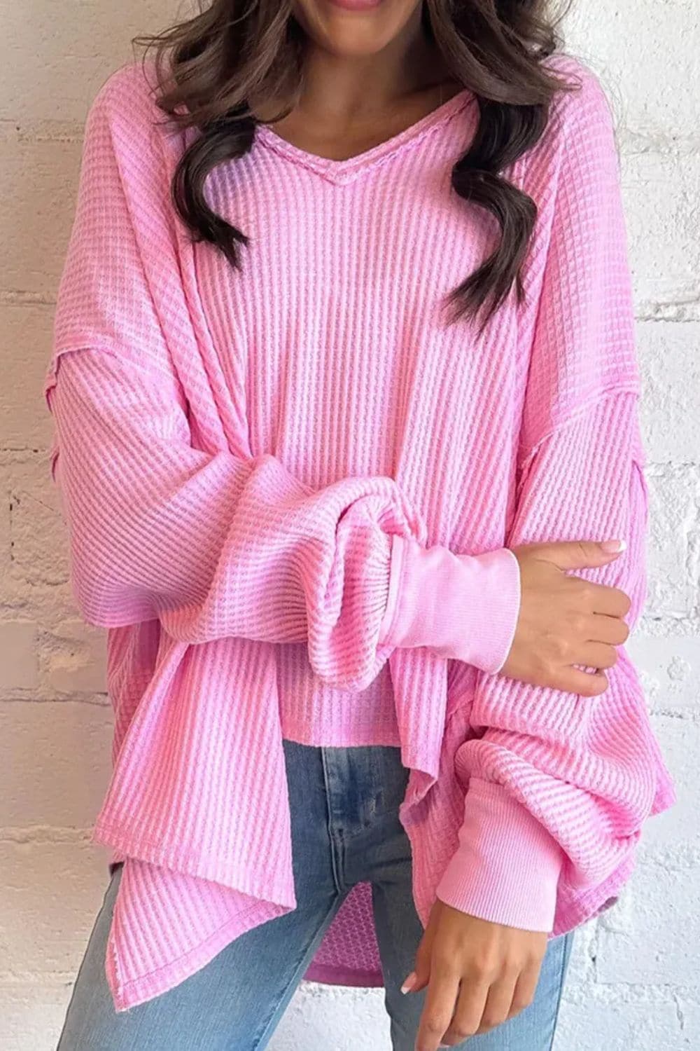 Waffle-knit v-neck blouse in pink, cozy elegance with long sleeves.