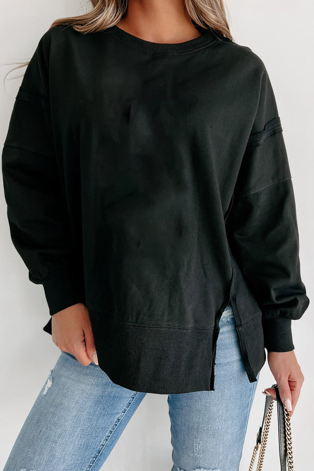 Chic black drop shoulder sweatshirt with exposed seams and side slits