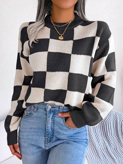 Checkered black and white mock neck long sleeve sweater worn with jeans.