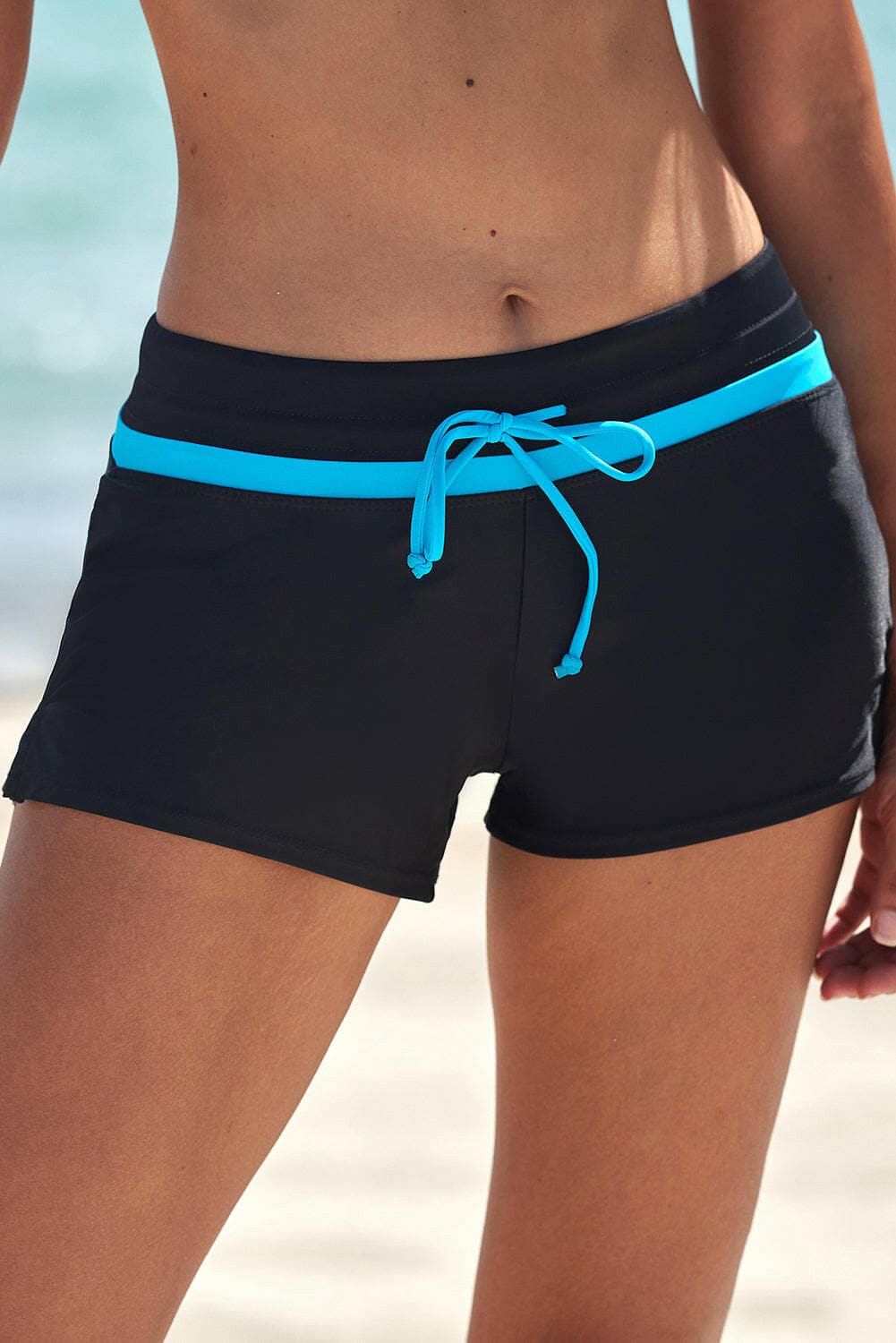 Full size drawstring swim shorts in black with turquoise trim, adjustable for comfort and flexibility.