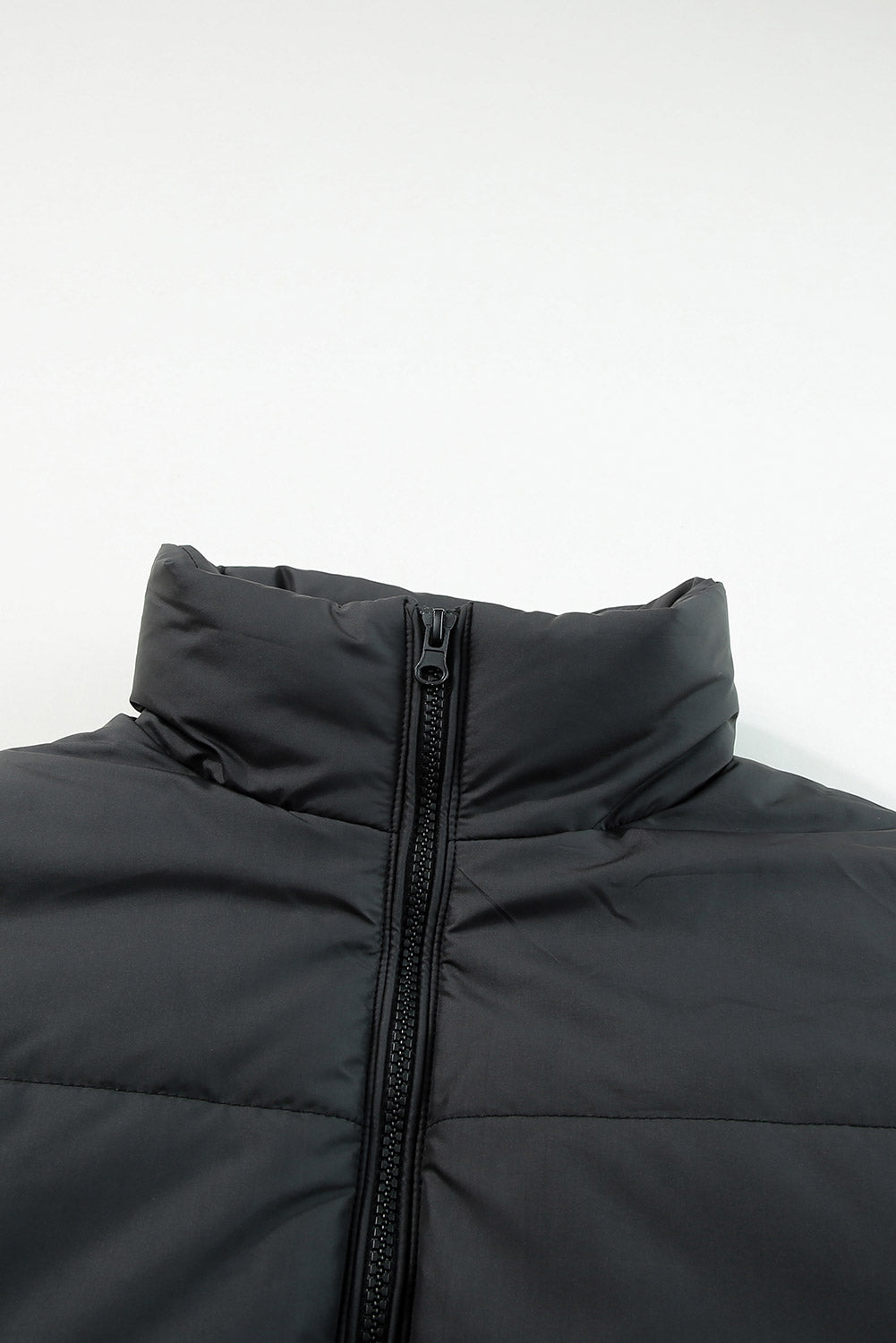 Sleek black puffer coat with zip closure and drawstring hem