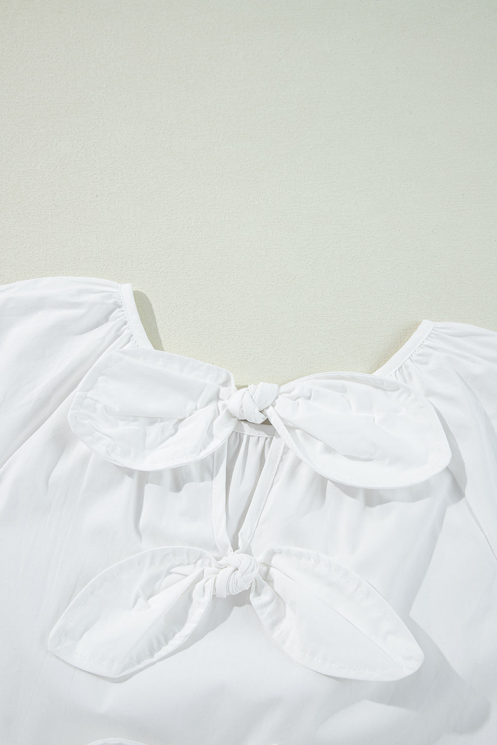 Chic white blouse with bow knot and cutout back design