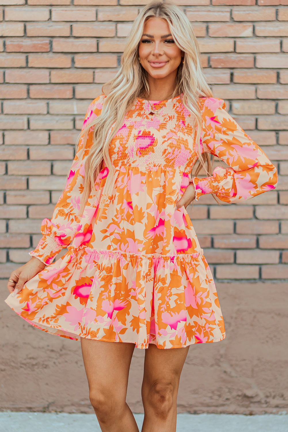 Orange smocked mini dress with abstract pattern and ruffled lantern sleeves.