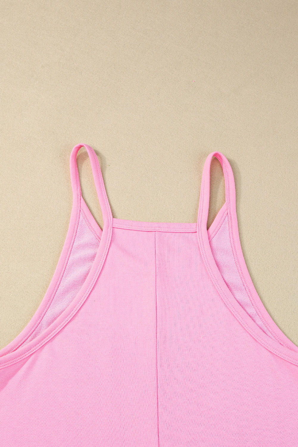 Chic pink sleeveless jersey romper with pockets and v-neck detail