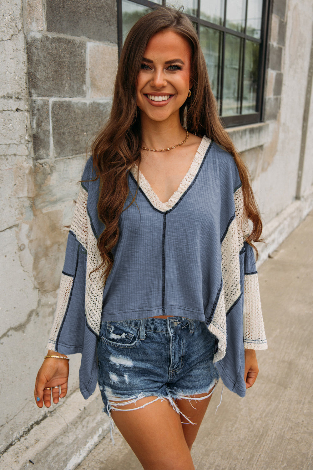 Ashleigh blue high-low loose top with crochet accents and exposed seams