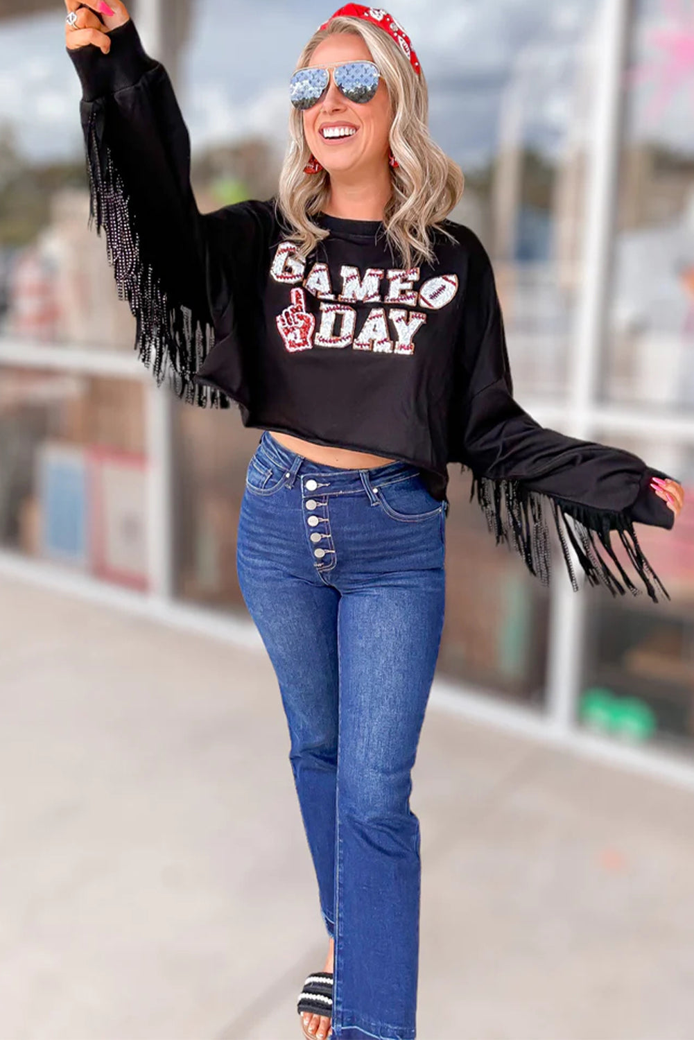 Sparkle on game day with a black cropped rugby sweatshirt featuring tassels and sequins