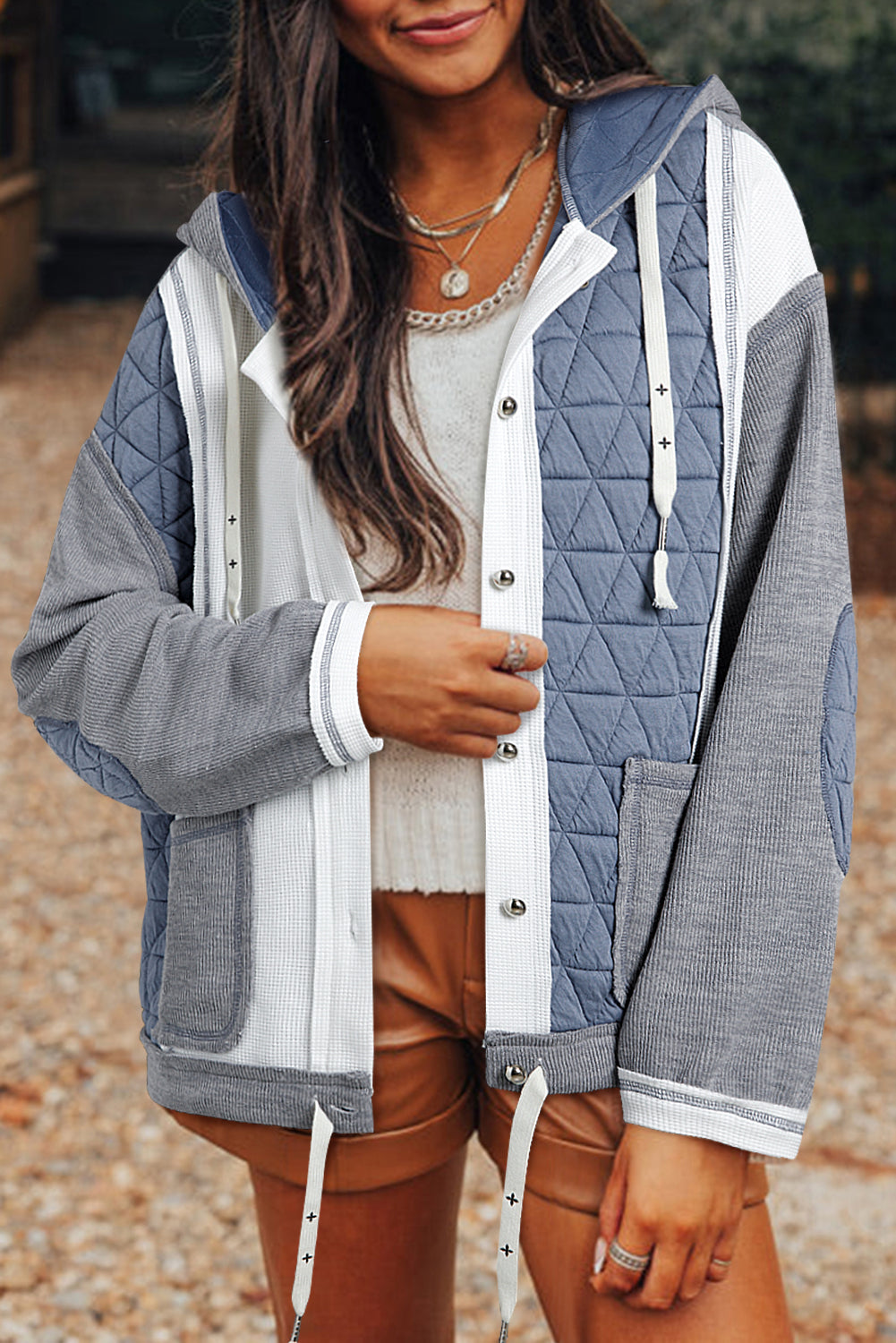 Light blue quilted textured patchwork loose fit hooded jacket with button closure.