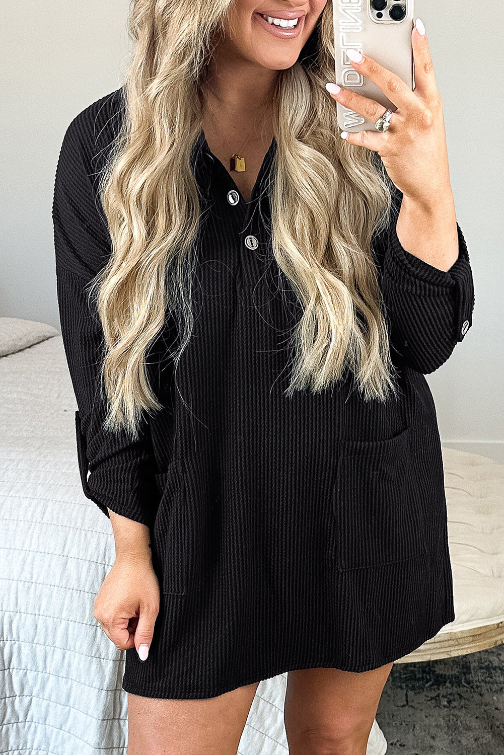 Chic black ribbed knit plus size mini dress with buttoned collar and roll tab sleeves