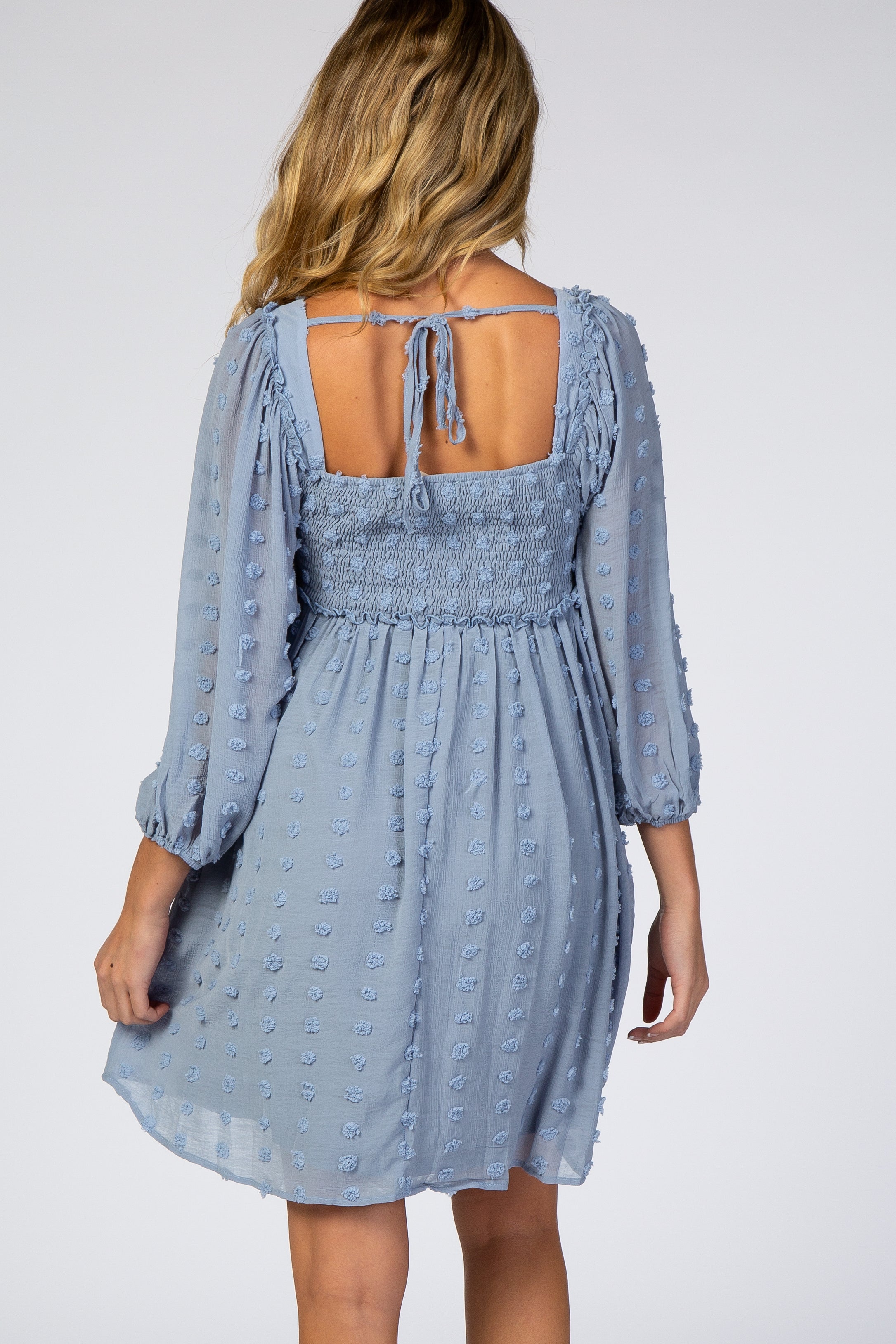 Maternity dress back view showing smocked panel and textured dot chiffon fabric