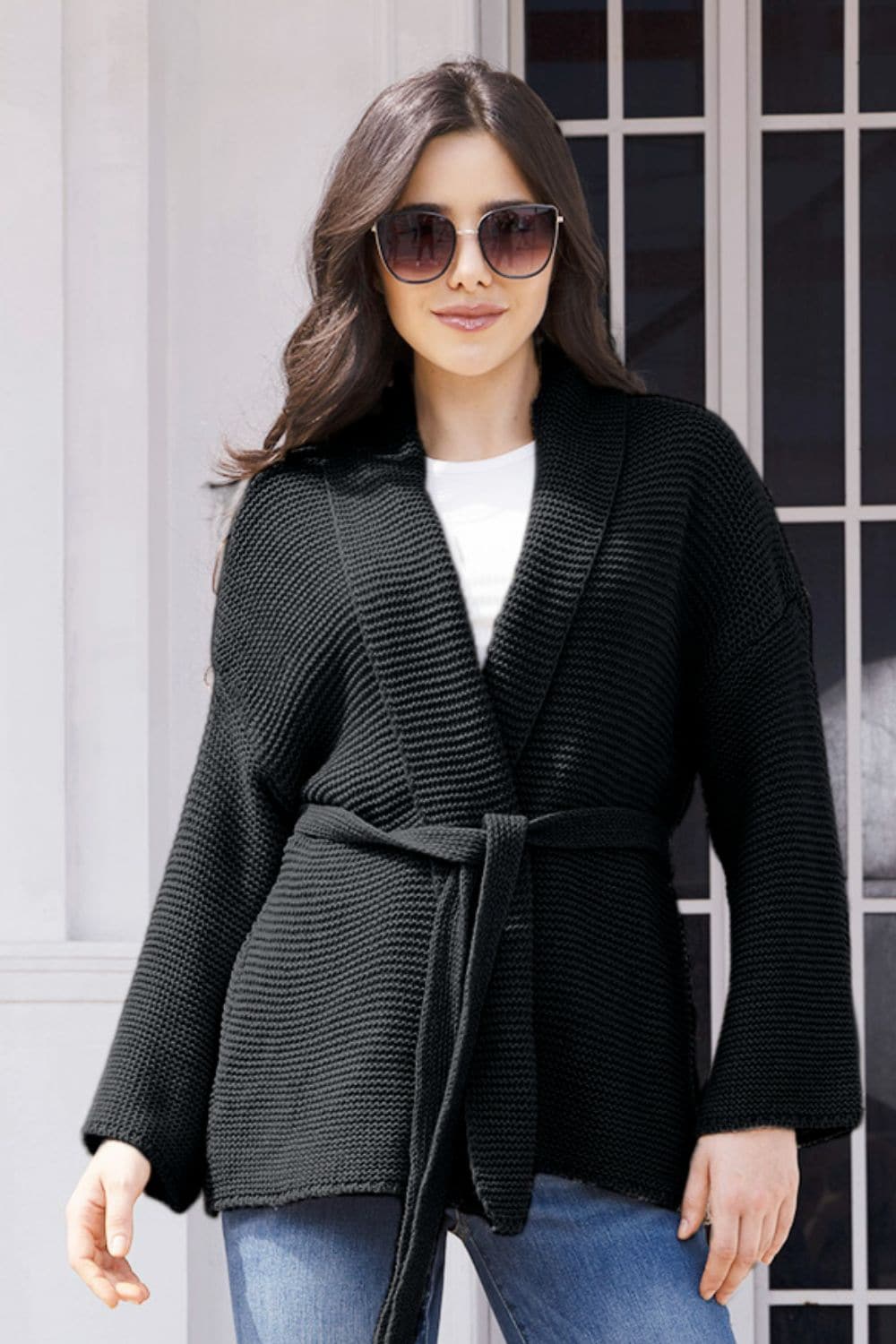 Woman wearing black open front long sleeve cardigan with sunglasses.