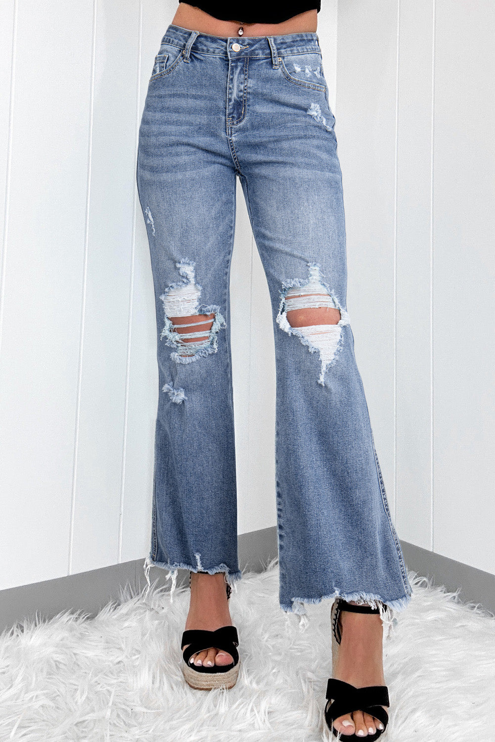 Dusk blue high-waisted flared jeans with distressed hem and ripped details