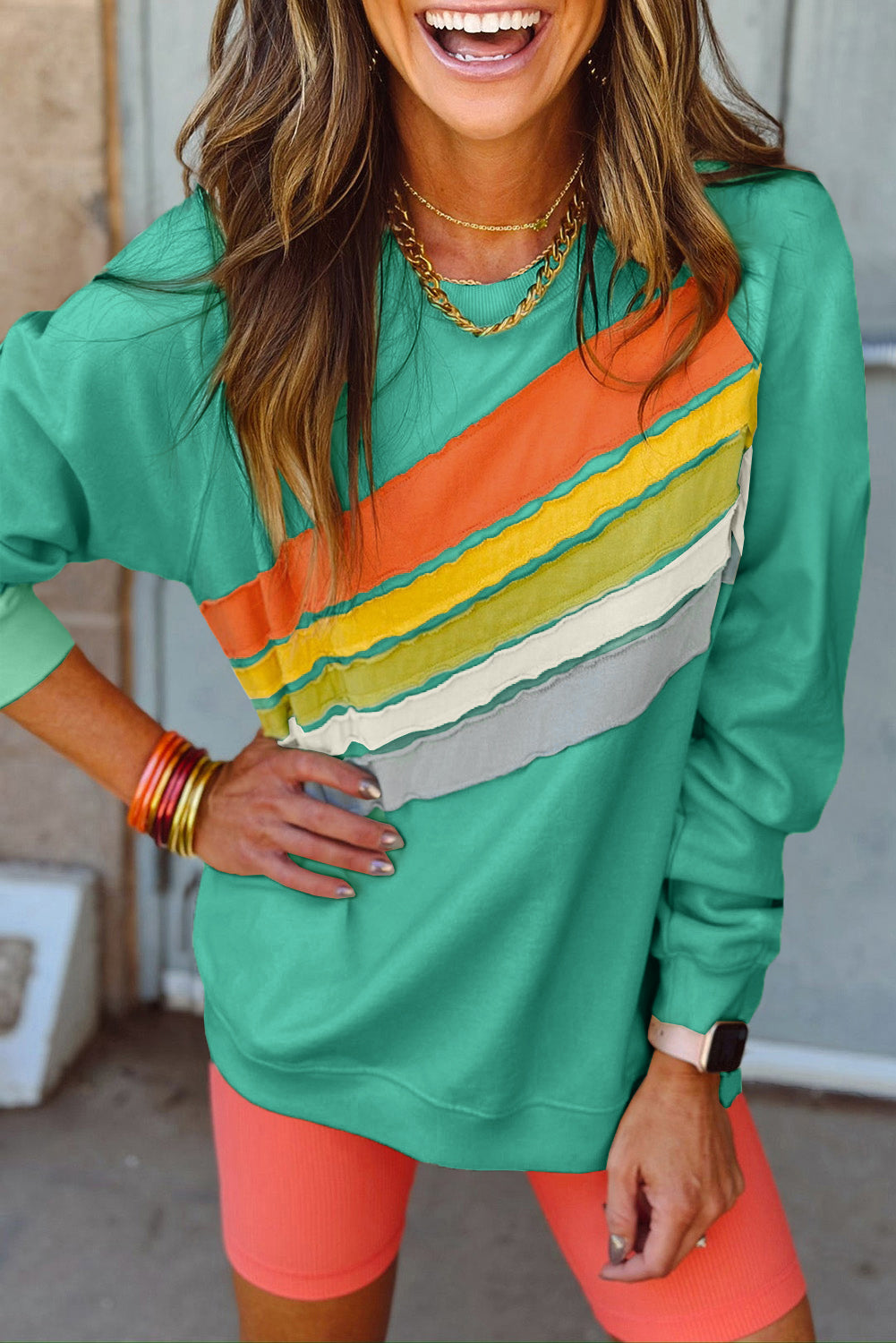 Vibrant mint green striped pullover with rainbow colorblock design