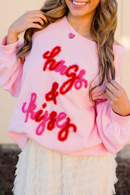 Pink embroidered raglan sleeve sweatshirt with "hugs and kisses" design.