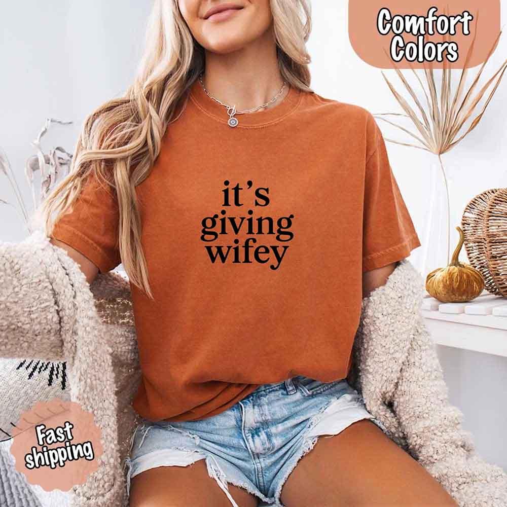 Close-up detail of the 'It’s Giving Wifey' retro-style text on the Adorb Custom Tees bridal shower t-shirt.