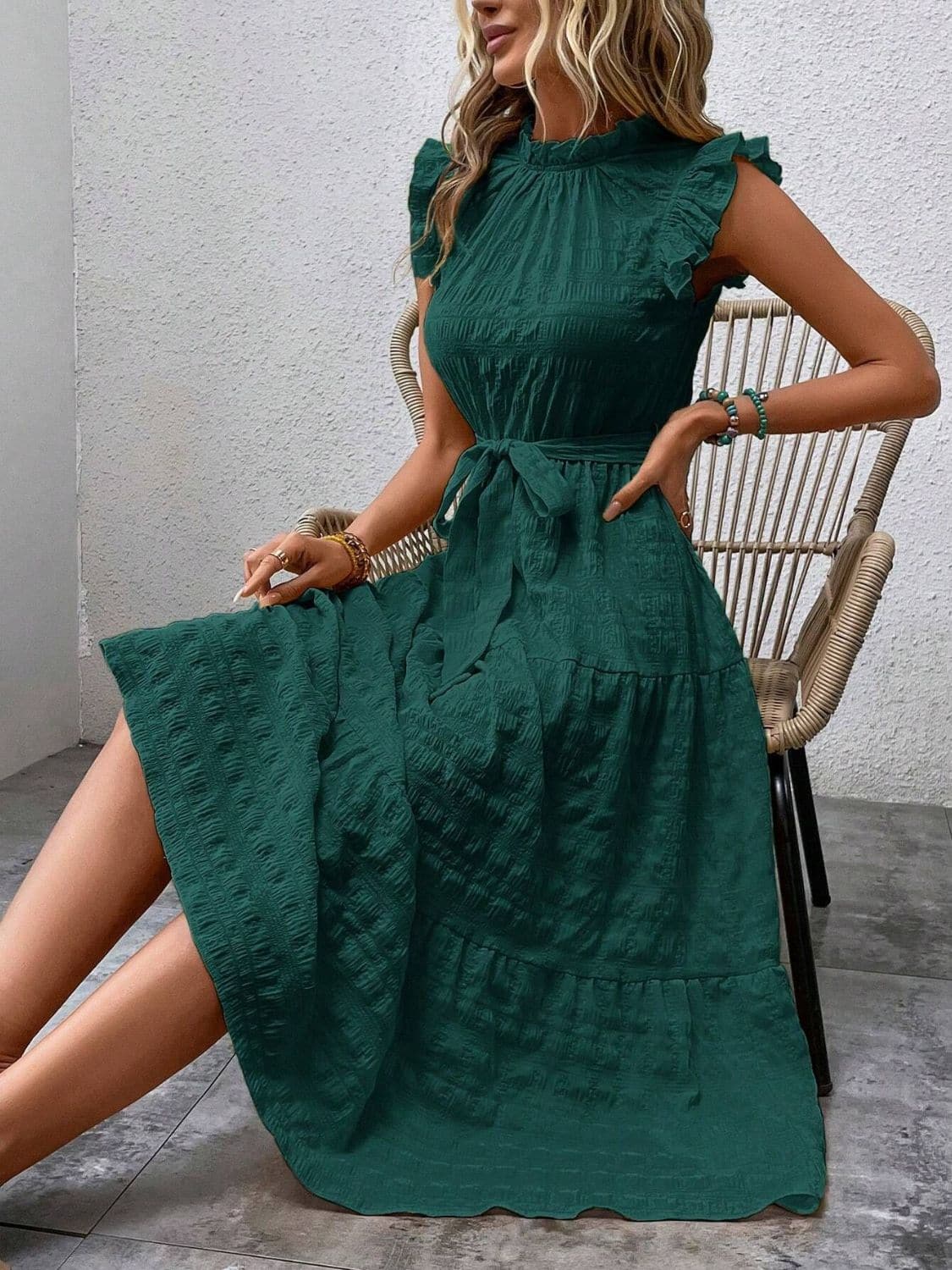 Ruffled cap sleeve midi dress with tied waist and opaque green fabric.